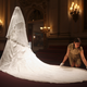 Exhibition curator, Caroline de Guitaut, adjusts the wedding dress of Britain's Catherine, Duchess of Cambridge, at Buckingham Palace in London July 20, 2011. Buckingham Palace expects record crowds this summer as up to 650,000 people are set to file into Queen Elizabeth's London residence and past the dress worn by Kate Middleton at her royal wedding to Prince William. The ivory and white garment, designed by Sarah Burton for Alexander McQueen, won over the fashion press and public when Middleton, now the Duchess of Cambridge and a future queen, walked up the aisle of Westminster Abbey in April. Picture taken July 20, 2011. REUTERS/Lewis Whyld/Pool (BRITAIN - Tags: ROYALS TRAVEL SOCIETY ENTERTAINMENT) - GM1E77M067A01